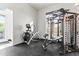 A functional trainer with exercise equipment sits beside a bright window in home gym at 10417 N 180Th Dr, Waddell, AZ 85355