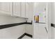 Bright hallway features white cabinets with black trim and leads to marble-tiled floors at 10417 N 180Th Dr, Waddell, AZ 85355