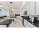 Bright kitchen featuring white cabinets, a gas cooktop, stainless steel appliances, and black countertops at 10417 N 180Th Dr, Waddell, AZ 85355