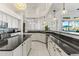 Bright kitchen featuring white cabinets, black countertops, mosaic tile backsplash, and modern pendant lighting at 10417 N 180Th Dr, Waddell, AZ 85355