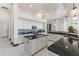 White kitchen cabinets with black counters, stainless appliances, tile floors, and a decorative light fixture at 10417 N 180Th Dr, Waddell, AZ 85355