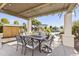 Covered patio featuring a dining table and chairs, with views of the pristine pool and lush landscaping at 10417 N 180Th Dr, Waddell, AZ 85355