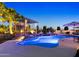 A luxurious pool at dusk featuring a waterfall feature, a trellis, and elegant landscaping at 10417 N 180Th Dr, Waddell, AZ 85355