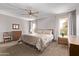 Spacious bedroom features a ceiling fan, dual windows, and a wooden dresser set for ample storage at 10609 W Concho Cir, Sun City, AZ 85373