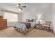 Bedroom showcasing a bed with decorative pillows, side tables, and a chest of drawers, illuminated by natural light at 10609 W Concho Cir, Sun City, AZ 85373