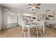 Bright dining area features a glass table, four white chairs, and a sliding glass door to a sunroom at 10609 W Concho Cir, Sun City, AZ 85373