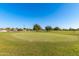 Scenic golf course with lush green grass and mature trees under a clear blue sky at 10609 W Concho Cir, Sun City, AZ 85373