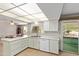 Kitchen features all-white cabinetry, a sink with a window view, and an adjacent dining area at 10609 W Concho Cir, Sun City, AZ 85373