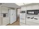 Kitchen area with white cabinets, a double-door refrigerator, and sleek, well-maintained appliances at 10609 W Concho Cir, Sun City, AZ 85373