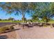 Outdoor seating area with tables and chairs surrounded by mature trees and a view of the golf course at 10609 W Concho Cir, Sun City, AZ 85373