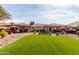 Expansive backyard featuring artificial grass, desert landscaping and covered patio for entertaining at 11010 W Acacia Dr, Sun City, AZ 85373