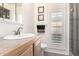 Well-lit bathroom with a shower, a single sink vanity, and white plantation shutters at 11010 W Acacia Dr, Sun City, AZ 85373