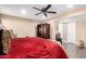 Cozy bedroom with a red quilted bedspread and a dark wood entertainment center at 11010 W Acacia Dr, Sun City, AZ 85373