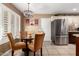 Cozy dining area featuring a glass table, comfortable seating, and stainless steel refrigerator at 11010 W Acacia Dr, Sun City, AZ 85373