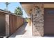 Side view of a beautiful house featuring a wood fence, brick accents, and meticulously kept landscape at 11010 W Acacia Dr, Sun City, AZ 85373