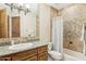 Charming bathroom with custom vanity, granite countertop, decorative mirror and tiled shower/bathtub combination at 12160 E Whispering Wind Dr, Scottsdale, AZ 85255