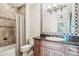 Bathroom with a custom vanity, granite countertop, designer mirror, and tiled tub with shower curtain at 12160 E Whispering Wind Dr, Scottsdale, AZ 85255