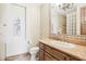 Elegant bathroom with a custom vanity, granite countertop, chandelier, and tiled shower with glass block window at 12160 E Whispering Wind Dr, Scottsdale, AZ 85255