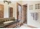 Modern bathroom with custom wood vanity and walk-in shower with decorative tile and a glass block window at 12160 E Whispering Wind Dr, Scottsdale, AZ 85255