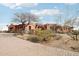 Desert home with native plants, brick driveway, and multiple garages offering ample parking and curb appeal at 12160 E Whispering Wind Dr, Scottsdale, AZ 85255