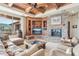 Living room with stone fireplace, entertainment center, coffered ceilings, and mountain views at 12160 E Whispering Wind Dr, Scottsdale, AZ 85255