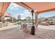 This covered patio features stone columns, textured concrete, and an outdoor dining set with a lovely pool view at 12160 E Whispering Wind Dr, Scottsdale, AZ 85255