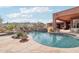 Stunning pool with waterfall feature, surrounded by desert landscaping and mountain views at 12160 E Whispering Wind Dr, Scottsdale, AZ 85255