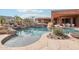 Beautiful pool with rock waterfall feature, desert landscaping, and mountain views at 12160 E Whispering Wind Dr, Scottsdale, AZ 85255