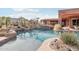 Beautiful pool with rock waterfall feature, surrounded by desert landscaping and mountain views at 12160 E Whispering Wind Dr, Scottsdale, AZ 85255