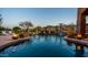 Tranquil pool with rock features, fire bowls, and lush greenery creating a serene outdoor retreat at 12160 E Whispering Wind Dr, Scottsdale, AZ 85255