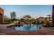 Inviting pool area with rock landscaping, fire features, and mature trees creating a private oasis at 12160 E Whispering Wind Dr, Scottsdale, AZ 85255