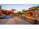 Outdoor living space with a custom stone fireplace, landscaping, and pool with rock features and a waterfall at 12160 E Whispering Wind Dr, Scottsdale, AZ 85255