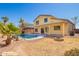 View of home's rear, showcasing a pool, outdoor seating area, desert landscaping, and a fire pit at 1244 W Castle Dr, Casa Grande, AZ 85122