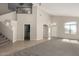 Bright living room with plush carpet, vaulted ceiling, neutral color scheme, with views of the stairway and front door at 1244 W Castle Dr, Casa Grande, AZ 85122