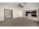 Spacious living room showcasing plush carpet, modern ceiling fan, and seamless flow into a contemporary kitchen at 1244 W Castle Dr, Casa Grande, AZ 85122