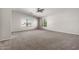 Expansive main bedroom with a ceiling fan, two windows, and neutral carpet at 1244 W Castle Dr, Casa Grande, AZ 85122