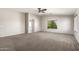 Large main bedroom featuring a ceiling fan, neutral carpet, and an attached bathroom at 1244 W Castle Dr, Casa Grande, AZ 85122