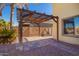 An attached wooden pergola provides a shady patio with brick pavers. and desert landscaping at 1244 W Castle Dr, Casa Grande, AZ 85122