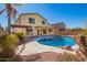 Beautiful backyard pool with rock features, surrounded by mature palms and attractive landscaping at 1244 W Castle Dr, Casa Grande, AZ 85122