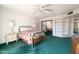 Bedroom features a full mirrored closet, shelving, green carpet and bed with Southwest print quilt at 13623 N 108Th Dr, Sun City, AZ 85351