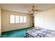 Spacious bedroom with ceiling fan, natural light from the windows and comfortable bed with colorful quilt at 13623 N 108Th Dr, Sun City, AZ 85351