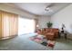 Spacious living room with a cozy leather sofa, ceiling fan, and sliding doors to backyard at 13623 N 108Th Dr, Sun City, AZ 85351