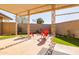 Covered patio with red Adirondack chairs, desert landscaping, and a privacy wall at 13623 N 108Th Dr, Sun City, AZ 85351