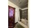 A bathroom with a tub and shower combo with tiled walls and a red decorative shower curtain at 1414 E Moreland St, Phoenix, AZ 85006