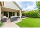 A backyard showcases lush lawn, a covered patio seating area, and an outdoor kitchen, perfect for enjoying outdoor living at 14360 W Windrose Dr, Surprise, AZ 85379