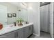 Neutral bathroom with a double sink vanity, large mirror, and stylish decor at 14360 W Windrose Dr, Surprise, AZ 85379