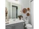 Cozy bathroom featuring a modern vanity, neutral decor, and decorative wall baskets at 14360 W Windrose Dr, Surprise, AZ 85379