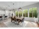 Dining room with a wooden table, six chairs, decorative lighting, and expansive windows at 14360 W Windrose Dr, Surprise, AZ 85379