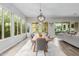 Dining area with a rustic table, six chairs, and expansive windows overlooking the backyard at 14360 W Windrose Dr, Surprise, AZ 85379