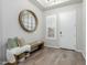 Stylish entryway featuring a bench with decor, a round mirror, and wood-look tile flooring at 14360 W Windrose Dr, Surprise, AZ 85379